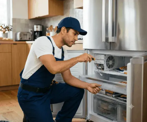 Técnico reparando refrigeradora americana